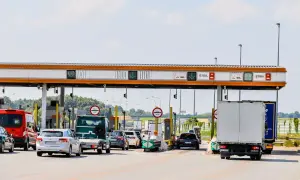 Kork na autostradzie bursztynowej. Samochody i ciężarówki czekają na bramkach opłat.