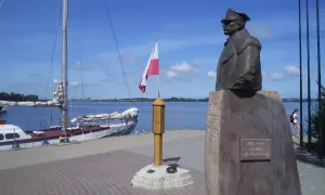 Pomnik upamiętniający zaślubiny Polski z morzem. Obok żaglowiec i polska flaga.