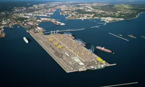 Nowoczesna budowa portu w Gdyni, z kontenerami, dźwigami i statkami, rozciąga się w stronę morza.