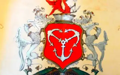 Herb Gdyni: czerwona tarcza z białym kotwicą, podtrzymywana przez dwa gryfy. Na górze czerwony smok i kotwica.
