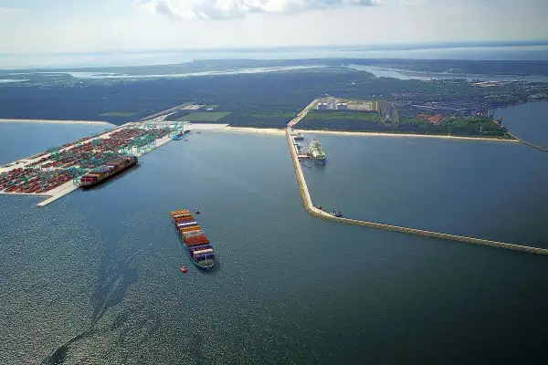 Ogromny port kontenerowy w Świnoujściu z wieloma statkami i dźwigami. W oddali widać terminal LNG.