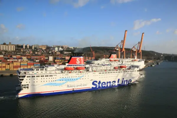 Dwa promy Stena Line w porcie, z widokiem na miasto i dźwigi.
