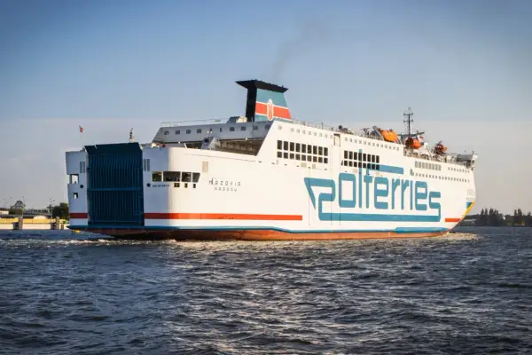 Prom "Mazovia" Polferries wypływa ze Świnoujścia. Statek z charakterystycznym niebieskim logo płynie po wzburzonej wodzie.